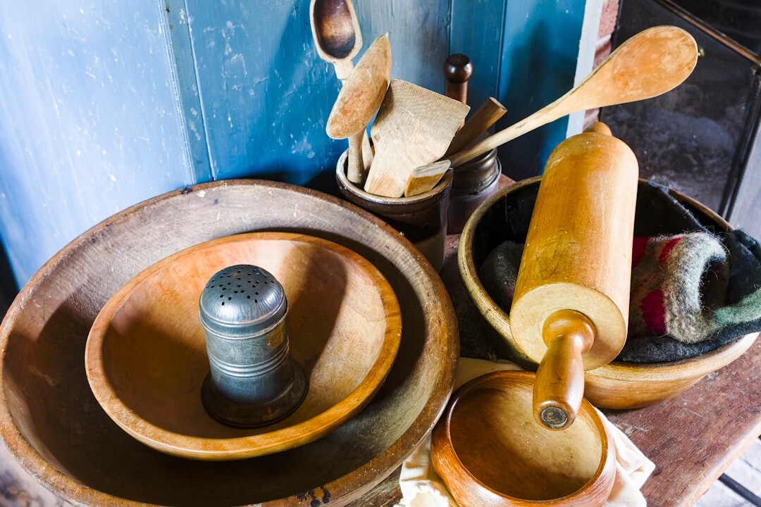 Wooden kitchen utensils, rolling pin and baking ingredients on a table